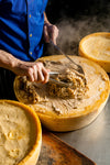 Pasta being prepared on a hot cheese wheel