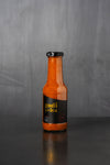 Bottle of Honey BBQ sauce with black label on a grey background